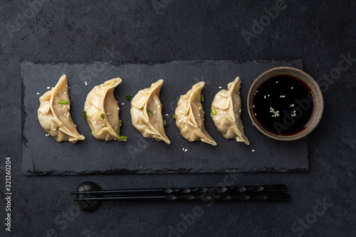 Traditional japaneese gyoza dumplings on black slate plate