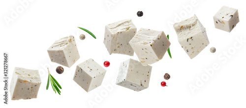 Falling feta cubes with herbs isolated on white background