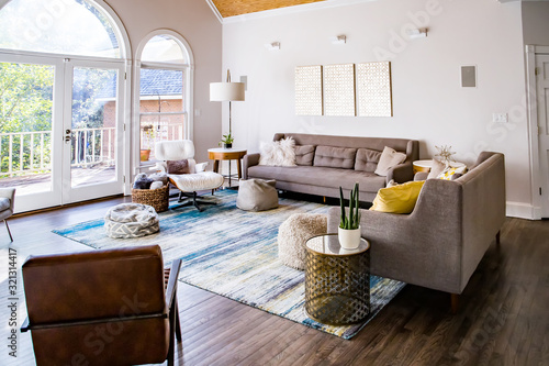 Mid century modern contemporary style living room den in a spacious open home with a vaulted ceiling and a pine wood ceiling and neutral gray couch and furniture