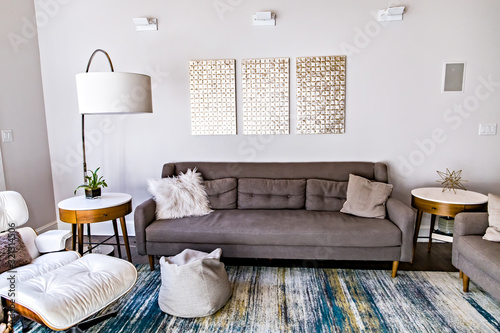 Mid century modern contemporary style living room den in a spacious open home with a vaulted ceiling and a pine wood ceiling and neutral gray couch and furniture