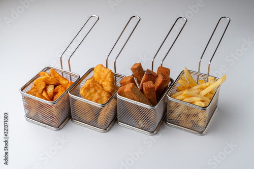 Set of hot deep fried beer snacks: crispy chicken nuggets, french fries and croutons isolated on white background