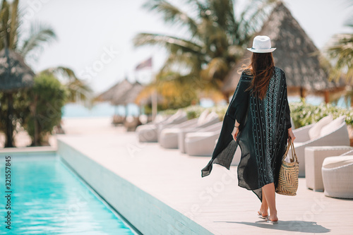 Woman relaxing by the pool in a luxury hotel resort enjoying perfect beach holiday vacation