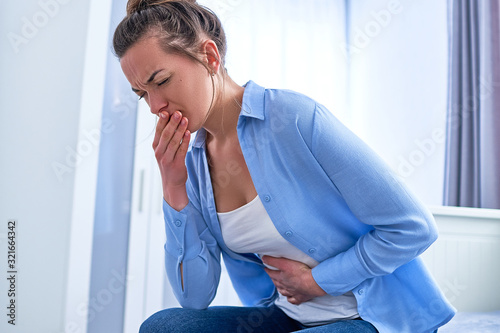 Woman suffers from nausea and vomiting during gastrointestinal system disease or food poisoning, health problems