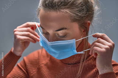 Healthy woman putting on medical protective mask to health protection and prevention during flu virus outbreak, epidemic and infectious diseases