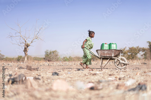 Little African Woman Transporting Fresh Water as a drought symbol