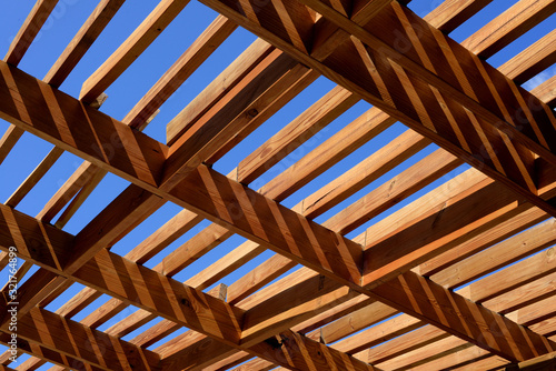 wooden pergola in the sun with blue sky