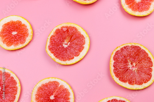 Slices of grapefruit on a pink background