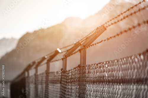 Military fence with barbed wire. Restricted area.