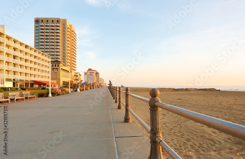 Virginia Beach at Sunrise. Photo shows hotels along the boardwalk and sand beach. The beach stretches three miles along the Atlantic ocean.