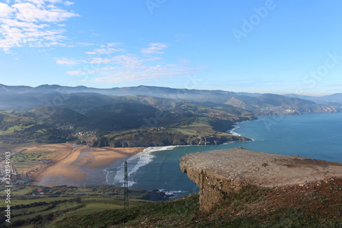 saliente en la montaña con vistas de un paisaje montañoso y playa de arena fina