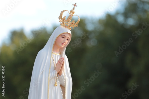 Beautiful statue of the Virgin Mary praying with her hands joined ,with a crown. Our Lady of Fatima. Paray-le-Monial, France.