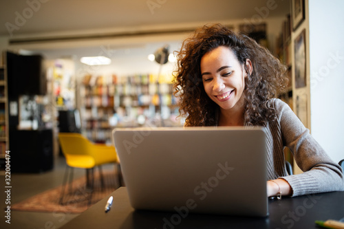 Young beautiful student girl working, learning in college library