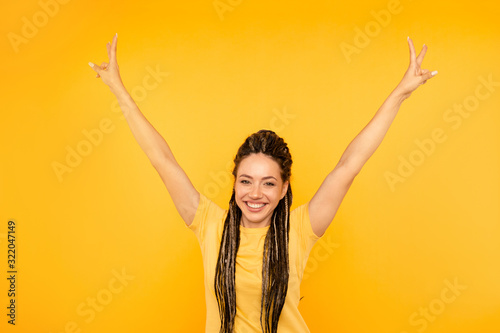 Exited happy woman posing in the yellow studio