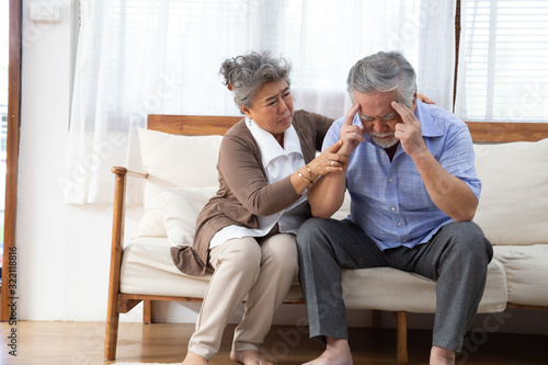 Asian senior retired couple holding hands and take care together at home, Alzheimer disease or suffering with dementia concept