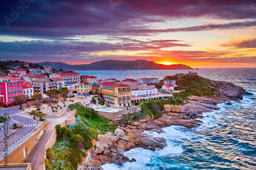 Amazing sunset view from the walls of the citadel of Calvi, the old town with historic buildings. Luxurious marina and very popular tourist destination. Corsica, France, Europe.