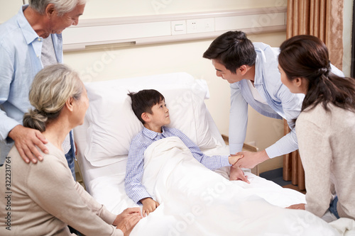 asian parents and grandparents visiting hospitalized child