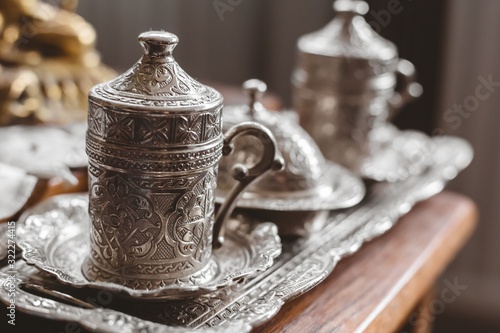 Closeup shot of an antique silver tea set with a blurry background