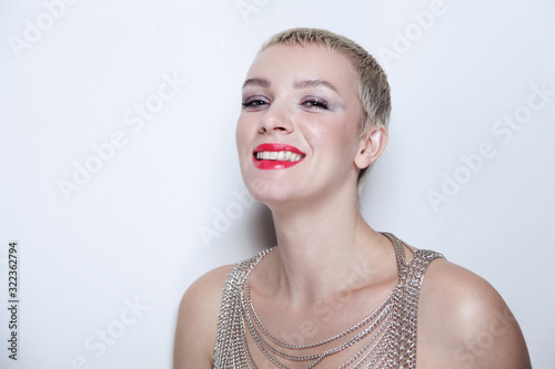 Vintage style portrait of young smiling woman with short blonde hair and fancy makeup