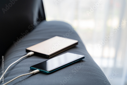 Mobile charging to smartphone from portable charger on Sofa..