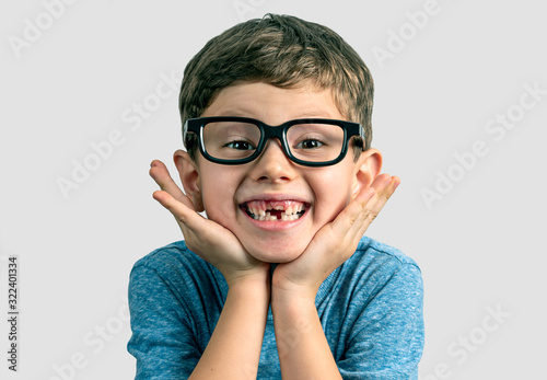 Very expresive toothless smile boy with hands on face and big eyeglasses