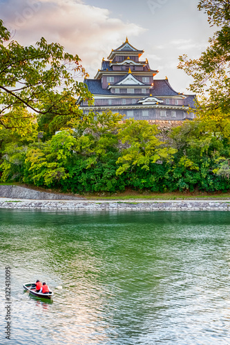 Okayama Crow Castle or Ujo Castle in Okayama City on the Asahi River in Japan. With Little Boat In Foreground.