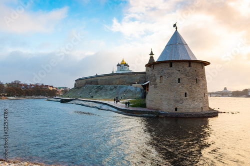 One of the main sightseeing in Pskov city - Ploskaya tower of Pskov Kremlin (also Pskov Krom) and the promenade of Pskova river and Velikaya river. Troitsky church and Kremlin walls on the background