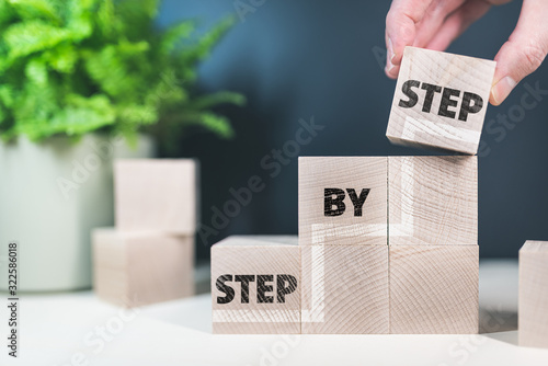 words step by step on wooden blocks, growth and progress concept