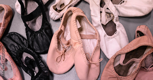 Looking down on a pile of worn pointe shoes, ballet slippers, ballet shoes