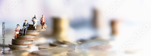 Miniature people: Elderly people sitting on coins stack. social security income and pensions. Money saving and Investment. Time counting down for retirement concept.