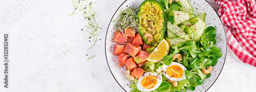 Ketogenic diet breakfast. Salt salmon salad with greens, cucumbers, eggs and avocado. Keto/paleo lunch. Top view, banner