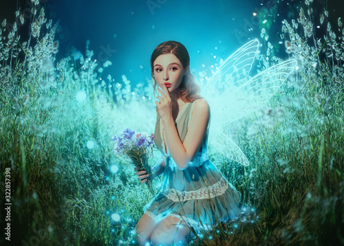 Art photo fantasy pixie butterfly. young fairy with glow wings holds bouquet flower. dark blue backdrop fabolous night Firefly star glitter light. Fingers show sign silence. cute face, makeup red lips