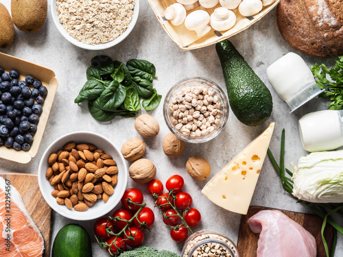 Healthy balanced ingredients background. Flat lay of fruits, vegetables, dairy products, cereals, legumes, dietary meat and fish, nuts and seeds on the table. Top view. Balanced healthy food concept