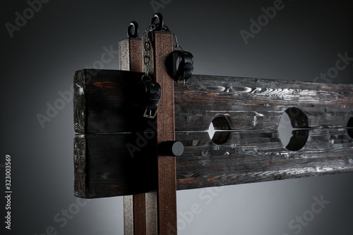 Handcuffs hanging on pillory for BDSM session