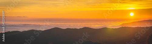 panoramic view of sunrise over the clouds on the mountain.