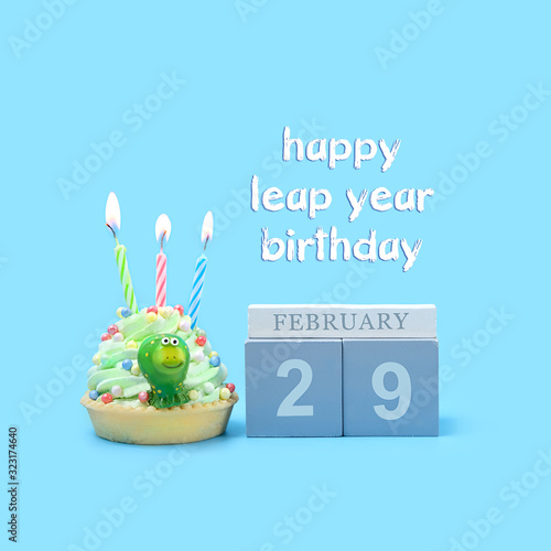 Happy Leap year Birthday greeting concept. February 29 date calendar, Frog and Birthday cupcakes on blue background. Leap day leap year 