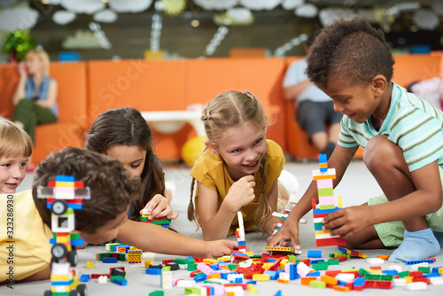 31.07.2017 - Kyiv, Ukraine. Group of funny kids playing with block toys indoor. Cute kids playing together indoor. Preschool early education.