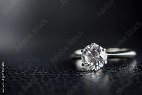Close up diamond ring jewelry on black leather background