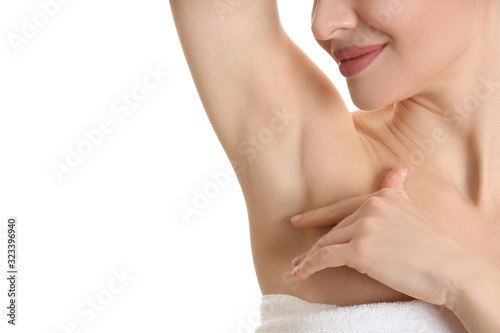 Young beautiful woman showing armpit with smooth clean skin on white background, closeup