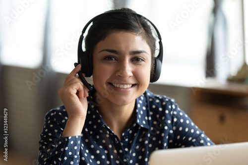 Portrait of smiling Indian female working on laptop