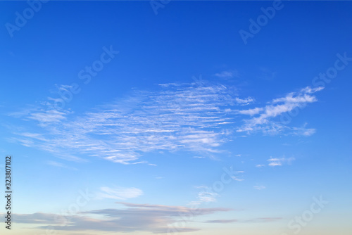 Wispy semitransparent cirrus and stratus clouds are high in the blue summer sky. Different cloud types and atmospheric phenomena. Skyscape.