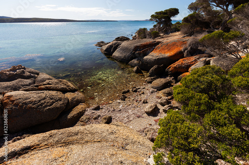 Beautiful coastline seascape with orange lichen rocks on sunny day in South Australia