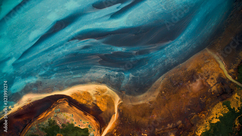 Aerial view from above on a green and blue glacier river stream in South Iceland. Beautiful patterns, textures and structures. Melting glacier, Global warming and climate change concept