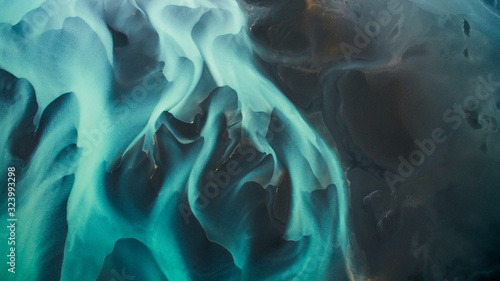 Aerial view from above on a green and blue glacier river stream in South Iceland. Beautiful patterns, textures and structures. Melting glacier, Global warming and climate change concept