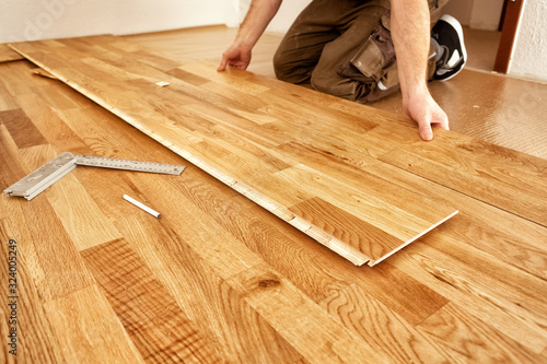 A craftsman lays oak parquet with a click system
