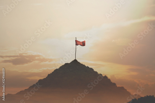 flag planted on top of a mountain, success concept