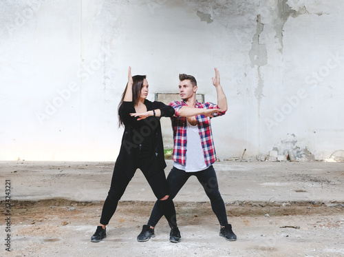 Boy and girl dancing hip-hop in old industrial building. Young couple art dance. Street urban lifestyle. 