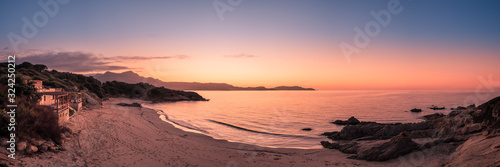 Sun setting over beach and calvi citadel in Corsica