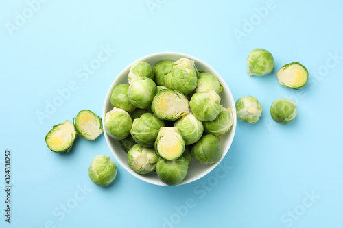 Bowl with brussels sprout on blue background, top view