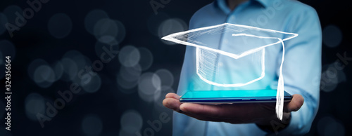 Man holding tablet with graduation cap on bokeh background
