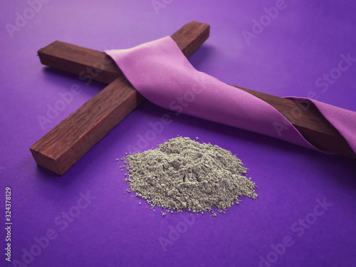 Good Friday, Lent Season, Ash Wednesday and Holy Week concept. Christian cross and ashes on purple background.